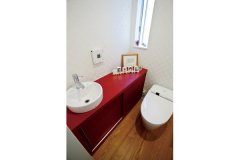 トイレ部分は赤い手洗い造作家具をポイントに楽しい空間をつくりあげた