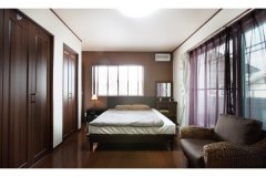 床、扉、家具、カーテンまで茶色で統一した寝室は、長年暮らしても飽きのこない落ち着いたムード