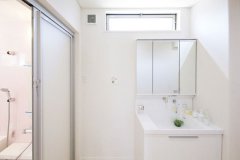 キッチンからも入れる洗面室。換気と採光を兼ねる窓を設けて室内を明るく