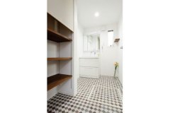 大容量の収納棚を設えた洗面室。シンプルな空間を床のデザインが引き立てている