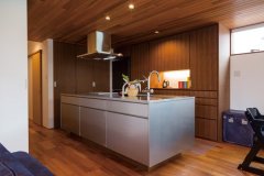 既製のキッチンに造作を組み合わせ、機能性とデザイン性を両立させた。背面の収納はチークの床ともキッチンともほどよく溶け込んでいる