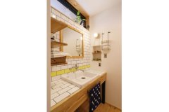家族で並んで使えるよう洗面は廊下のオープンスペースに設置。アクセントの黄色のタイルの配置は、何度もデザイン画を描いてもらって考えたそう