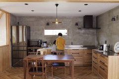 キッチンは壁を下地用の軽量モルタルで仕上げ、「男前」な雰囲気。壁付けのレイアウトは、背後の空間が広く使えます。