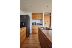 造作棚の扉は木目を合わせ、天板の高さをシステムキッチンと揃えるなど、無駄のないシンプルさの中に光るこだわりが、空間に価値を生む。