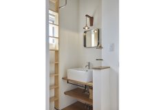 「AXCIS」で購入した鏡がシンプルな空間のアクセントになっている2階の独立洗面。壁掛けの梯子を降ろせばロフトへの動線に。
