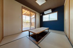 モザイク柄の畳や青い壁などモダンさを取り入れた和室。テーブルは畳んで床に収納できる。