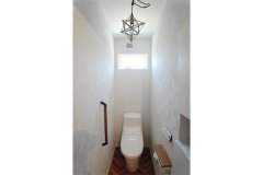 2階のトイレは1階と雰囲気を変えて。ヘリンボーンのクロスの床とオシャレな照明がアクセント
