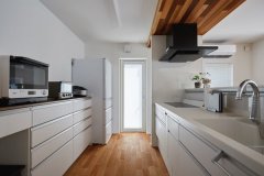 清潔感のある白色で統一したキッチンは広々タイプ。作業中の手元が見えないようにカウンターの高さを調節。