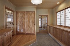 無垢の木目が美しい玄関ホール。玄関収納の板戸は矢羽根の形の模様をあつらえ、格調高い空間に。