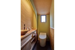 竹張りの腰壁やあじろ天井など、職人技が光る１階のトイレ。消臭・調湿効果のある珪藻土の壁は、表情豊かなクシ引き仕上げ。