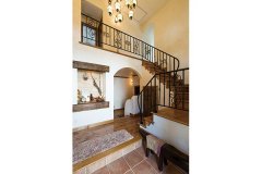 アイアンの手すりをあしらった階段が、ゆったりとした玄関にラグジュアリーな雰囲気を演出している。