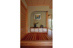 来客を迎える垂れ壁をアールにして優しい雰囲気に。ラオス松の床が美しい模様を描く。