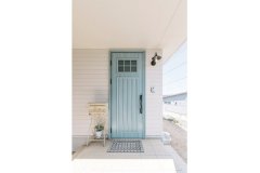 アイスブルー色のキュートな扉が白い壁によく映える玄関扉。スッキリと爽やかな印象を与えています。