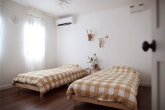 2階主寝室の壁にはお気に入りの雑貨をバランスよく飾って。風がそよぐとそっと揺れる真っ白なカーテンが印象的。
