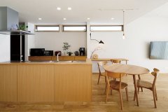 キッチンはカウンターの高さを下げてオープンな印象に。前側はタモの柾目板ですっきりと。