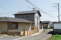 建物西側。周囲の家並みとは向きを変えながらも、落ち着いた塗り壁の外観が風景にそっと溶け込みます。