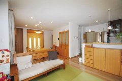 木のソファや収納棚など自然の色であふれたリビング。畳スペースは適度な柔らかさと吸音性に優れた側面を持つ