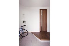 R壁が柔らかな印象の玄関。自転車をしまうこともできる
