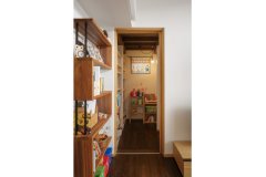 2階書庫への階段下はおもちゃや本を収納するスペースとして有効活用。照明を設けて子どもたちの隠れ家のように