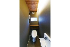 間接照明やダークな壁紙で落ち着いた雰囲気のトイレは、造り付け家具にもこだわった