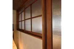 DKに隣接するリビングと寝室の建具は、「掛谷建設」が造作したオリジナル。高い透明度と耐衝突性を持つポリカーボネートを使用することで光が通り、室内に広がりが生まれる。レトロなテイストが、ご主人が塗った珪藻土壁の柔らかな表情とも良く合う。