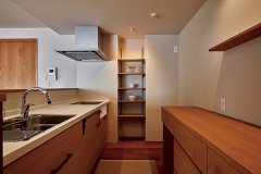 ホワイトオークで造作したキッチンの背面収納。構造上移動できないパイプスペースの壁に飾り棚を組み込み、圧迫感を解消。