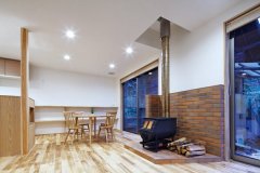 床材だけでなく、造作家具にも使用された無垢材や、薪ストーブ、レンガタイルが部屋全体にやさしく安心した空気を与えている。大開口の窓も印象的