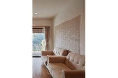 リビングのソファ奥には、壁面にエコカラットを採用。調湿性を向上させ、梅雨時期でも快適に過ごすことができる。