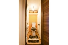 トイレは、一面だけ鮮やかなオレンジの壁紙を使って個性ある空間を演出