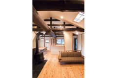 勾配天井と迫力ある梁が織り成すオープンな空間。I型キッチンは壁付けにせず、アイランド風に。回遊性もよく使いやすい 
